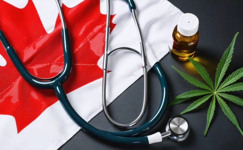 A stethoscope lying over the Canadian flag, with CBD oil bottles in the foreground, illustrating the intersection of medicine, Canadian regulations, and CBD treatments for healthcare providers.